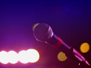 A microphone in a dark room with blurred lights in the background
