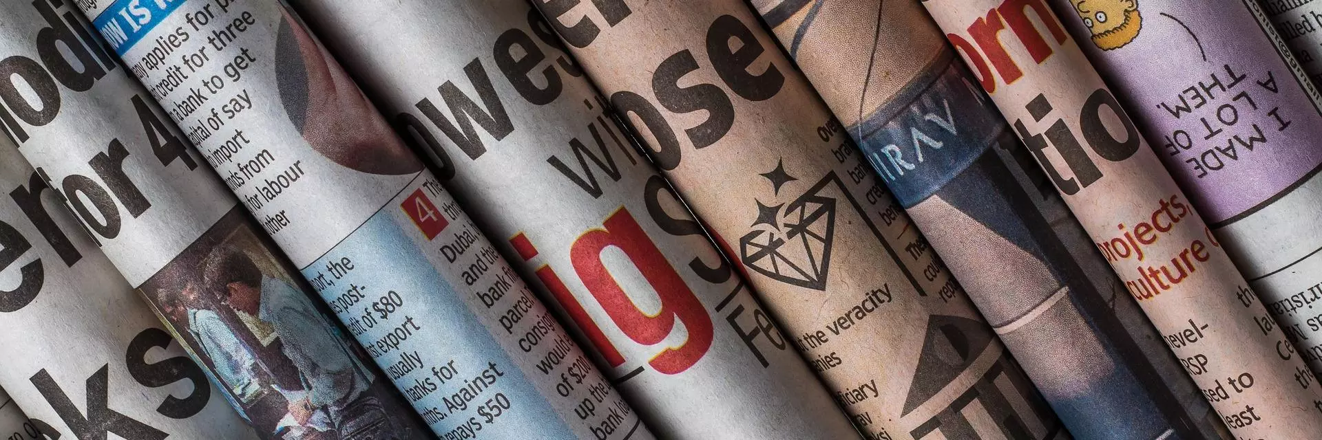 Several newspapers rolled up and grouped together